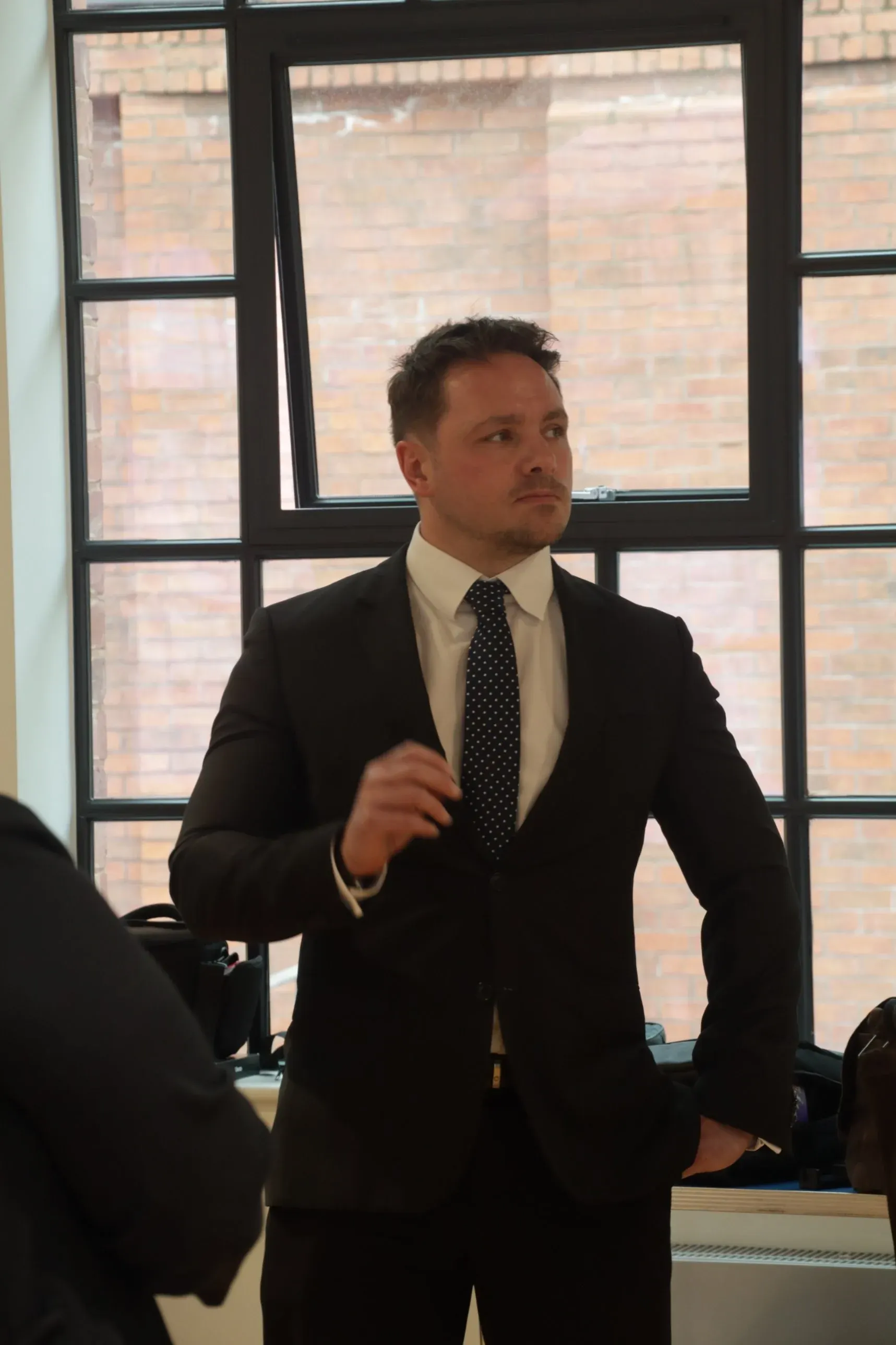 Dr Lewis Haydon standing at a Dragons’ Den-style pitch event in Birmingham, UK
